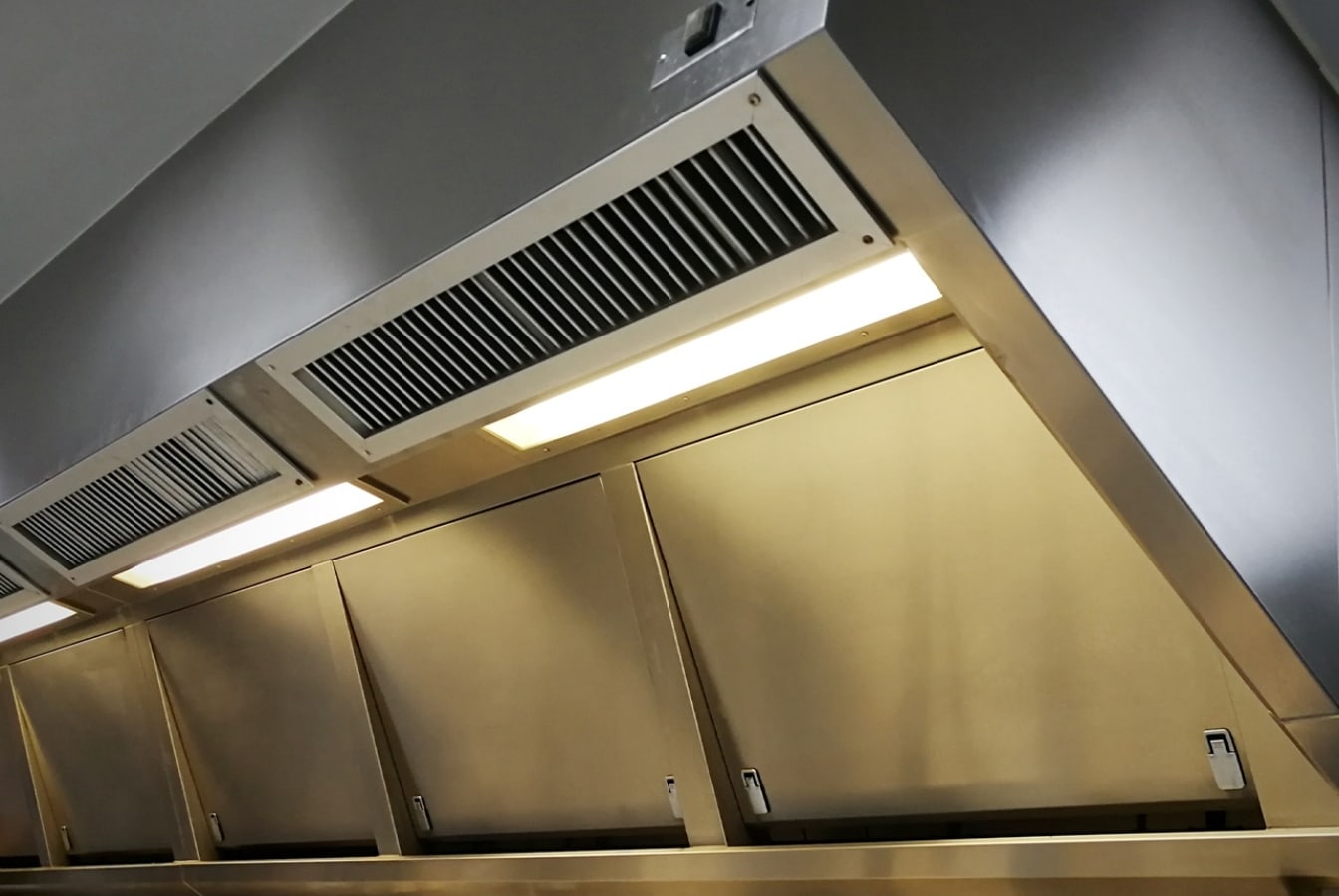 a clean commercial kitchen ventilation system in a restaurant kitchen
