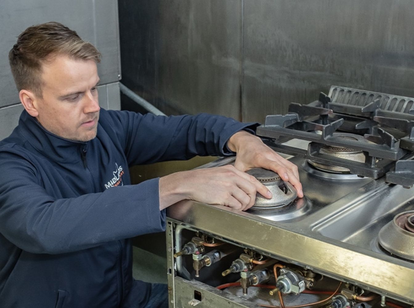 A Midlands engineer performing repairs to a gas cooker to make sure the equipment is compliant with Commercial Kitchen Gas Regulations